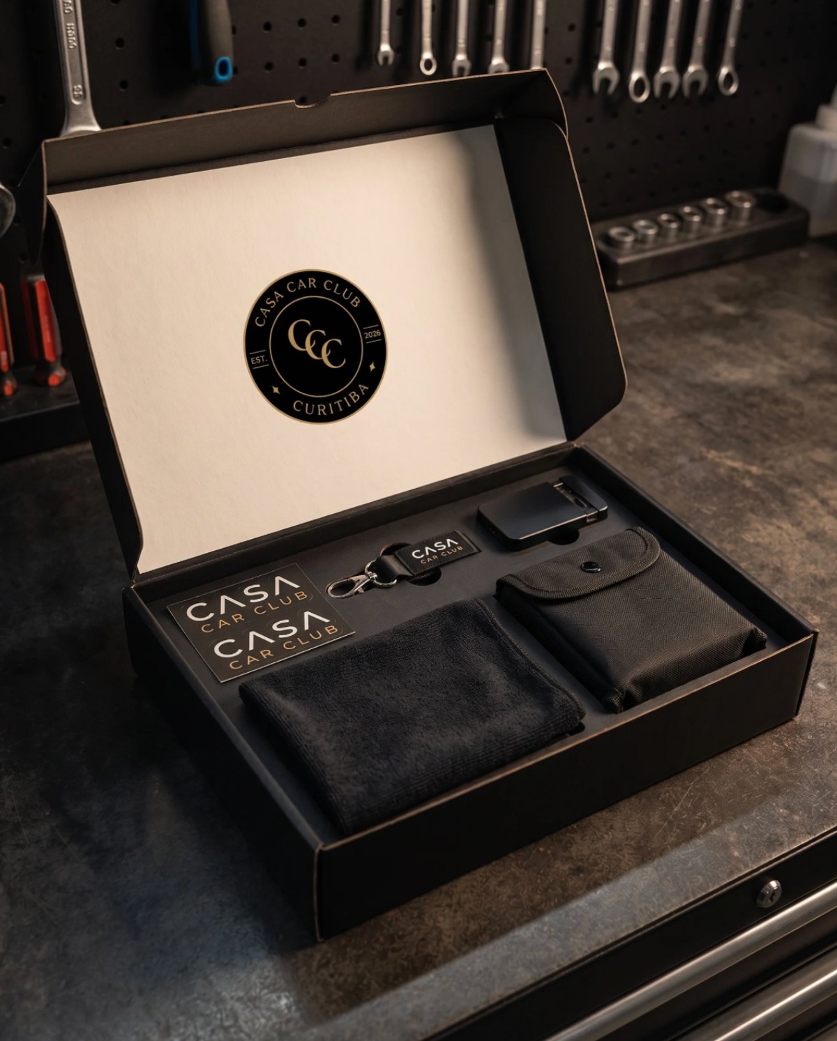 CASA Box Prata aberta, com adesivos, chaveiro, flanela e necessaire.